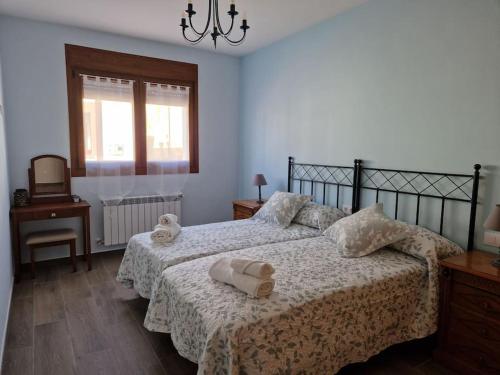 a bedroom with two beds and a chandelier at Casa Rural Villa Cárcavas in Maello