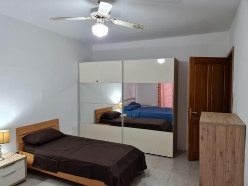 a bedroom with two beds and a ceiling fan at 4 Bedroom House at Saint julians in St. Julianʼs