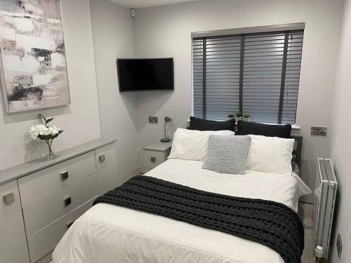 a bedroom with a large bed and a television at Luxury Canalside Apartment with Hot Tub in Poynton