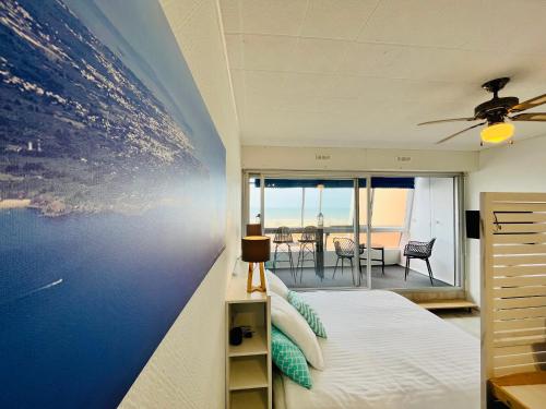 une chambre avec un lit avec un tableau sur le mur dans l'établissement Studio panoramique océan du Marina, à Saint-Jean-de-Monts