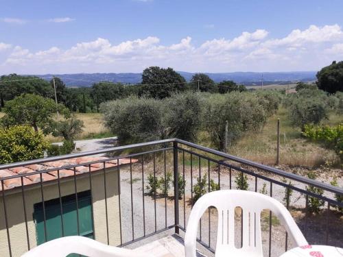 a balcony with two white chairs and a pool at Costa del Sole 46 in Cetona