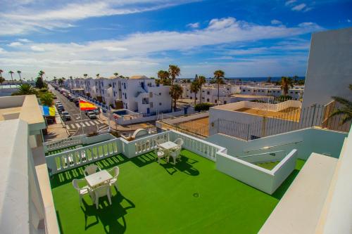 widok z dachu budynku z zielonym trawnikiem w obiekcie Apartamentos Corona Mar w Puerto del Carmen