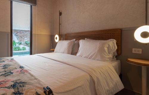 a bedroom with a large bed with white sheets and pillows at Soy Local Insignia in Cartagena de Indias