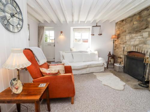 ein Wohnzimmer mit Sofa und Tisch in der Unterkunft Woodbine Cottage in Moreton-in-Marsh