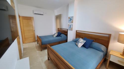a small bedroom with two beds and a lamp at Amar'e Aparthotel & Spa in Las Terrenas