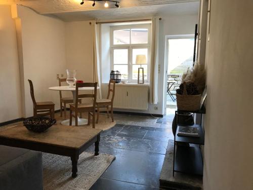a living room with a table and a table and chairs at Maison de charme à Crupet et le gîte la suite in Crupet