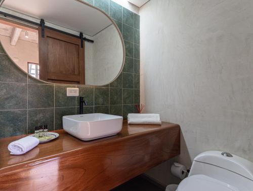 a bathroom with a sink and a mirror and a toilet at Soy Local Insignia in Cartagena de Indias