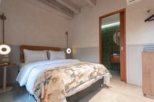 a bedroom with a large bed and a bathroom at Soy local insignia in Cartagena de Indias