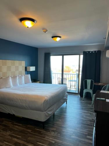 a hotel room with a bed and a balcony at Trade Winds on the Bay in Rockland