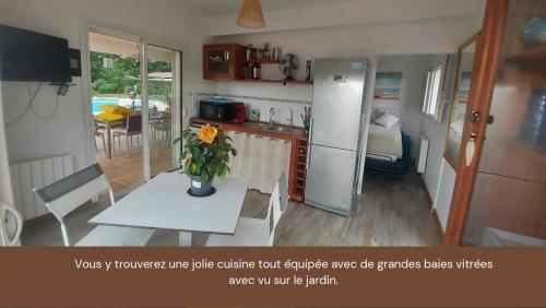 uma cozinha com uma mesa com um vaso de flores em Mignon petit appartement indépendant em Mérignac