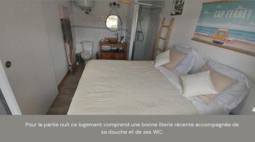 ein Schlafzimmer mit einem großen Bett mit weißer Bettwäsche und Kissen in der Unterkunft Mignon petit appartement indépendant in Mérignac