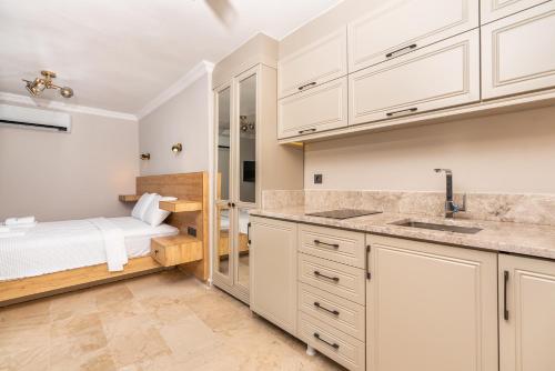 カルカンにあるVilla Altayの白いキャビネット付きのキッチン、ベッド1台が備わる客室です。