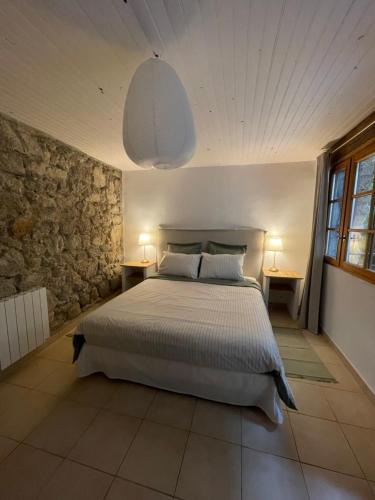 1 dormitorio con 1 cama con 2 mesas y 2 lámparas en Gîte Pêcher au Château des Pauses en Saint-André-de-Majencoules
