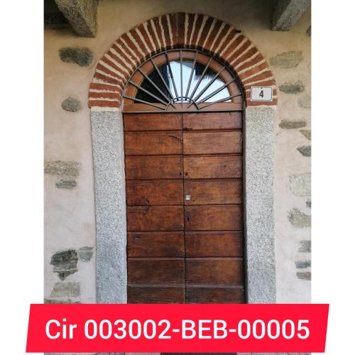 una puerta de madera en un edificio con ventana en BeB LORTALLINO, en Ameno