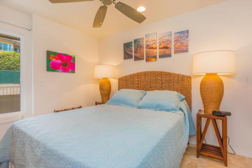 a bedroom with a bed and two lamps and a window at 2 Bedroom Kapaa Condo with Pool and AC 115 in Kapaa
