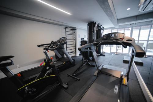 a gym with two treadmills and two exercise bikes at Brut by Slaviero Hotéis in Balneário Camboriú
