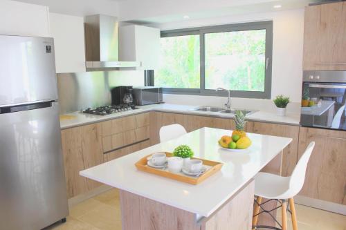 a kitchen with a table with a bowl of fruit on it at Amar'e Aparthotel & Spa in Las Terrenas
