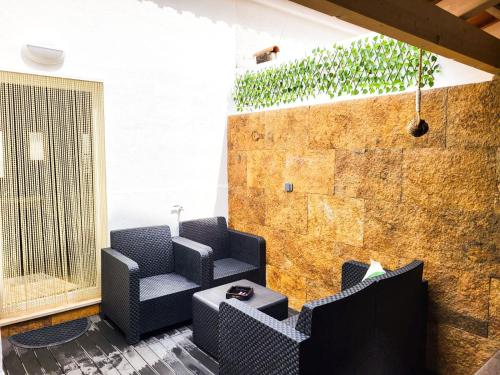 a room with two chairs and a table and a brick wall at Cheirinho a Mar AL in Nazaré