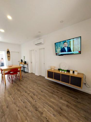 a living room with a flat screen tv on the wall at Cheirinho a Mar AL in Nazaré