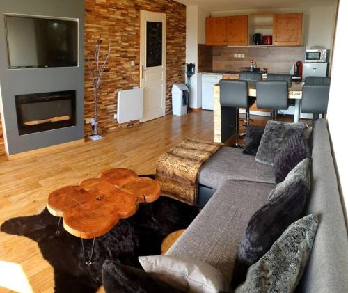 un salon avec un canapé et une table dans l'établissement Exceptionnel Appart 3 chambres+ terrasse, à Chamrousse