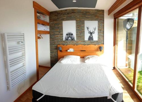 une chambre avec un lit et un mur de briques dans l'établissement Exceptionnel Appart 3 chambres+ terrasse, à Chamrousse