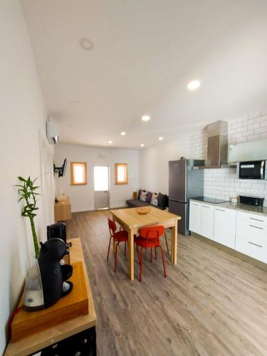 a living room and kitchen with a table and chairs at Cheirinho a Mar AL in Nazaré