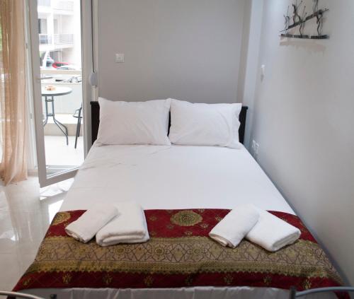 a bed with two pillows and two towels on it at Mina's Spacious Studio Apt : June '23 Renovated in Thessaloniki