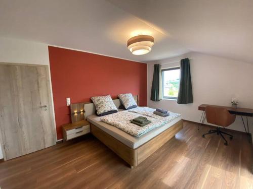a bedroom with a bed and a red wall at Eifelvilla zur Kirsche - Wellness und Spa in Burbach