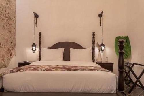 a bedroom with a large bed with white sheets at Soy Local Insignia in Cartagena de Indias