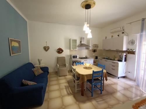 a living room and kitchen with a table and a blue couch at La Casetta di Nonna Anna in Palermo