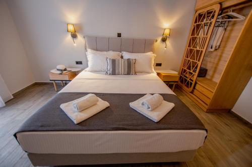 a bedroom with a large bed with two towels on it at Thea comfy living in Nea Vrasna