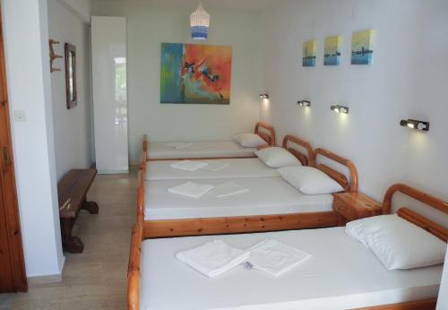 Un grupo de 4 camas en una habitación en Mama's Rooms - Eurostudiosnaxos, en Naxos Chora