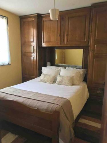 a bedroom with a large bed with wooden cabinets at Recanto do Lameiro in Monção