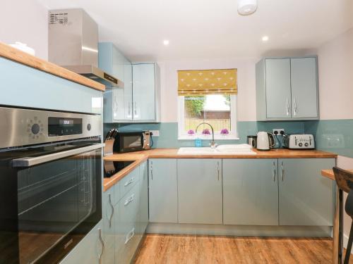 a kitchen with blue cabinets and a sink at Strawberry Fields Annex in Wisbech