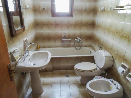 y baño con aseo, bañera y lavamanos. en Mama's Rooms - Eurostudiosnaxos, en Naxos Chora
