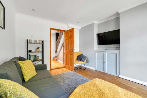 a living room with a couch and a tv at The Retreat on Risbygate in Bury Saint Edmunds