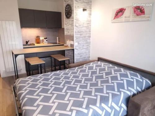 une chambre avec un grand lit et une cuisine dans l'établissement Escapade en bord de mer : studio à la plage !, à Courseulles-sur-Mer