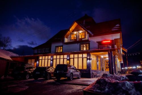 a building with cars parked in front of it at night at Гуцульська світлиця in Bukovel