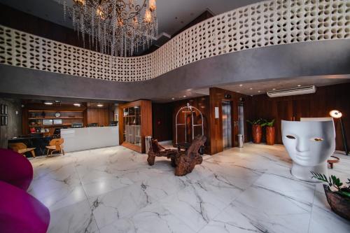 a lobby with a large marble floor and a chandelier at Brut by Slaviero Hotéis in Balneário Camboriú