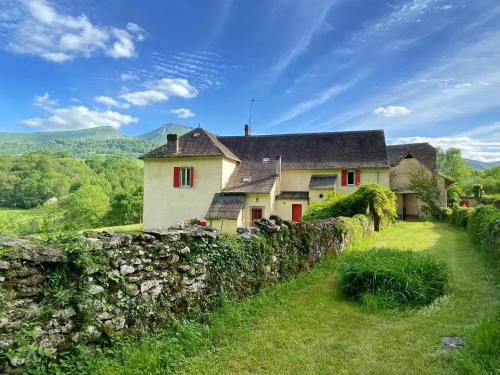 een oud huis met een stenen muur in een veld bij Chez Jeanne, superbe corps de ferme, vue imprenable in Issor