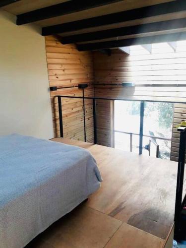 a bedroom with a bed and a wooden wall at Entre maitenes Bariloche in San Carlos de Bariloche