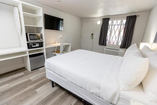 a bedroom with a white bed and a microwave at Oneway Brunswick in Brunswick