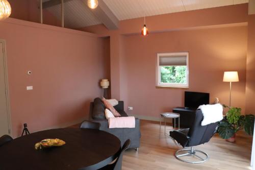 a living room with a table and a couch at Het vrije uitzicht Giethoorn in Giethoorn