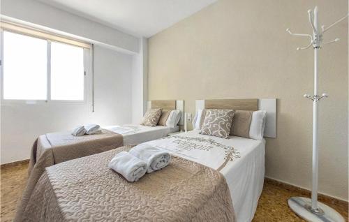 La Torre的住宿－Amazing Apartment In El Puig De Santa Maria With Outdoor Swimming Pool，一间卧室配有两张带毛巾的床