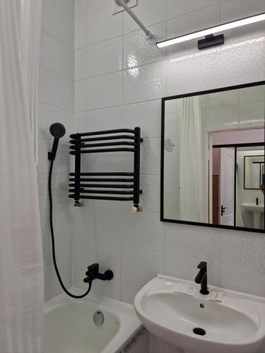 a white bathroom with a sink and a mirror at SOPRANO APARTMENT KRAKIVSKA 34 in Lviv