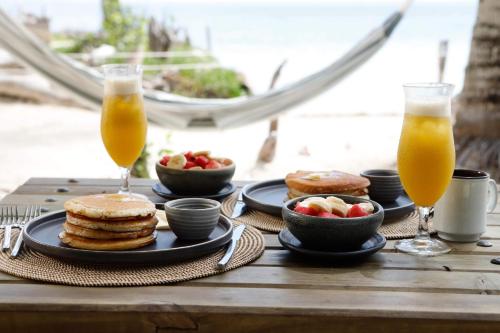 una mesa con tortitas y fruta y dos vasos de zumo de naranja en Sal Si Puedes, en Tintipan Island