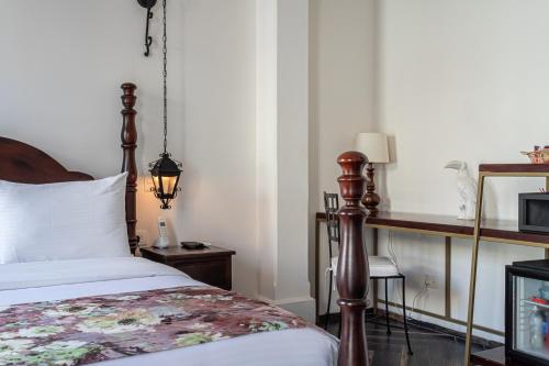 a bedroom with a bed and a table with a microwave at Soy Local Insignia in Cartagena de Indias