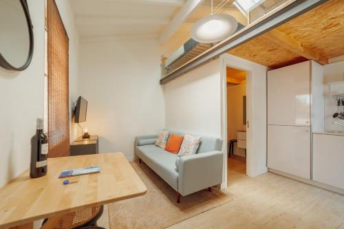 a living room with a couch and a table at Mezzanine Stylish Apartments by Vacationy in Porto