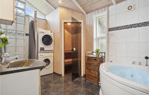 FalenにあるBeautiful Home In Hemmet With 3 Bedrooms, Sauna And Wifiのバスルーム(バスタブ、洗濯機付)