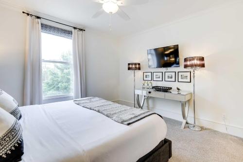 ein weißes Schlafzimmer mit einem Bett und einem Schreibtisch in der Unterkunft Fayetteville Vacation Rental Near UA Campus in Fayetteville